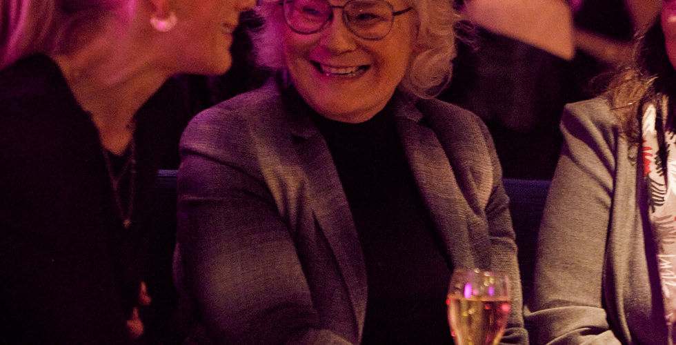Zwei Frauen sitzen zusammen, lachen und stoßen an – echte Begegnungen, Austausch und Verbindung stehen im Mittelpunkt.