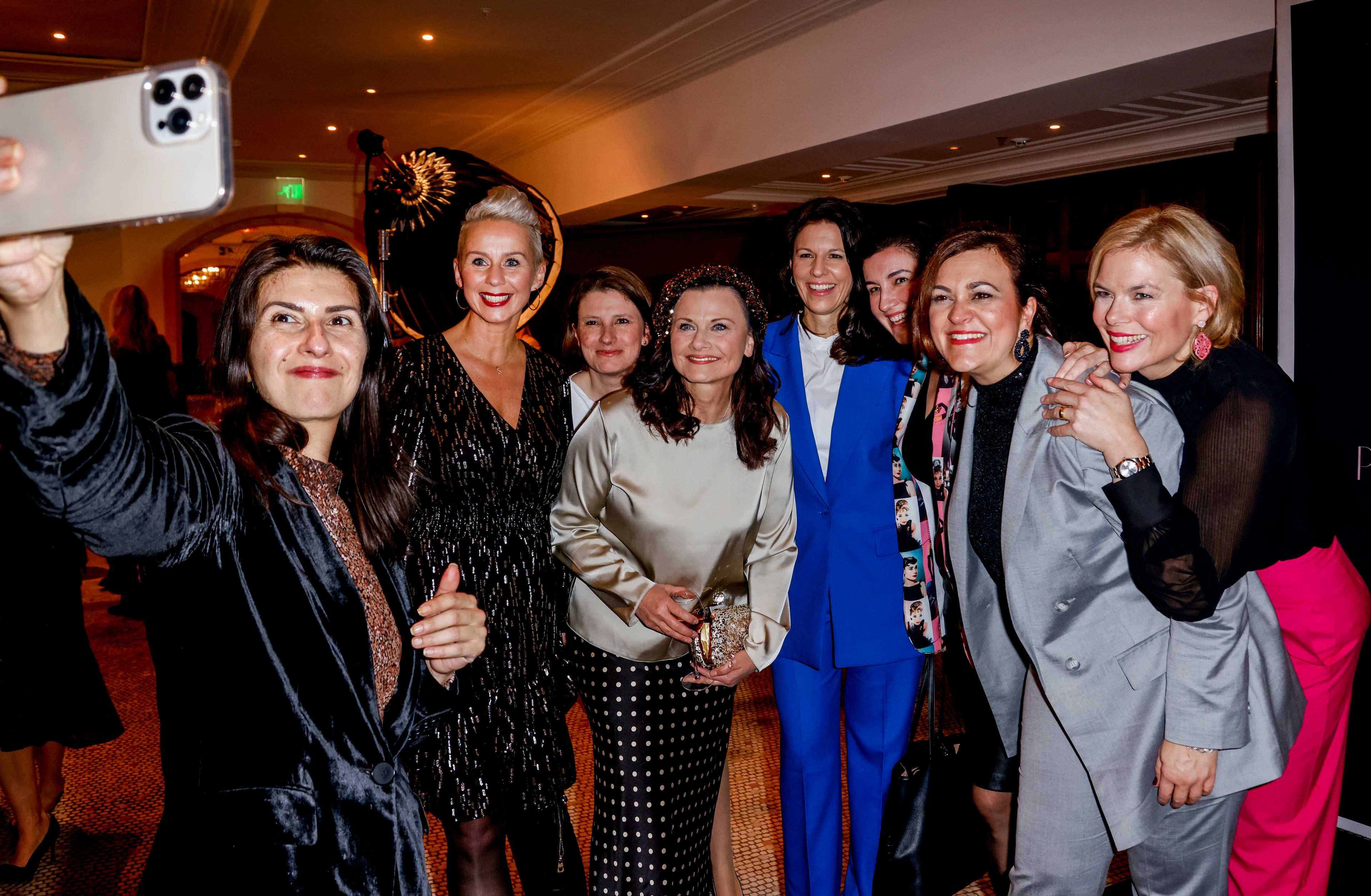 Gruppe von Frauen macht ein Selfie bei einem Event und lacht gemeinsam in die Kamera.