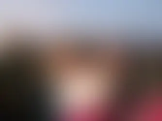 Zwei Frauen umarmen sich auf einer Bühne und halten einen großen Spendenscheck, während das Publikum auf einer Dachterrasse applaudiert und eine Moderatorin spricht.