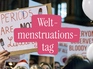 Menschen demonstrieren mit Schildern für Menstruationsgerechtigkeit. Im Vordergrund ist ein Protestplakat mit der Aufschrift „Periods are not a luxury“ zu sehen. Darüber liegt ein pinkes Textelement mit der Aufschrift „Weltmenstruationstag“.