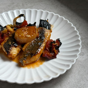 לברק בטאבון על מצע כרישה ועגבניות בצלחת