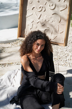 Laura Arana posing with one of her calming wall reliefs