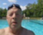 Robert Paxon smiles poolside after swimming laps—capturing determination, joy, and his commitment to raising funds for older adults through his swimming.