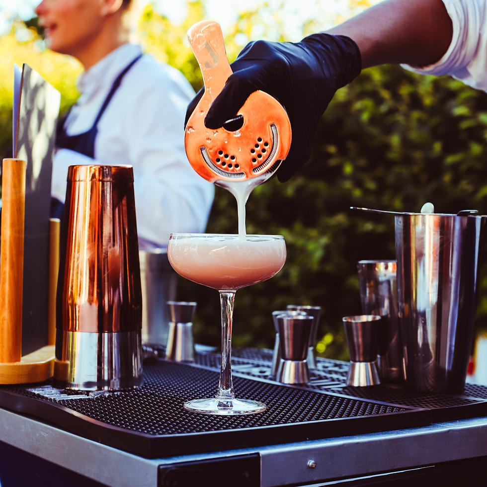 En cocktail der bliver hældt op i et glas