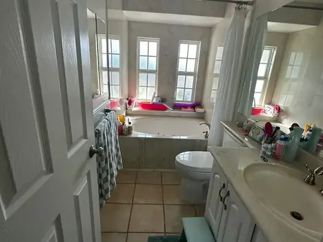 Before photo of a dated bathroom in Oceanside with original vanity, mirror, and lighting prior to remodel