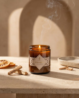 Close-up of a lit Onenessliving candle on a wooden table, commercial product photography in Andalusia.