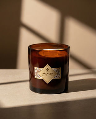 Close-up of a lit Onenessliving candle on a wooden table, commercial product photography in Andalusia.