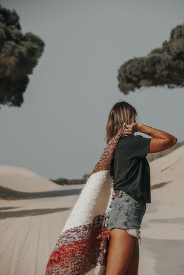 Close-up of a textured Armonia Shop rug, beautifully styled by Marie in the natural setting of Tarifa's Punta Paloma dunes.