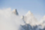 The Grand Teton pokes out of the clouds into the sun.
