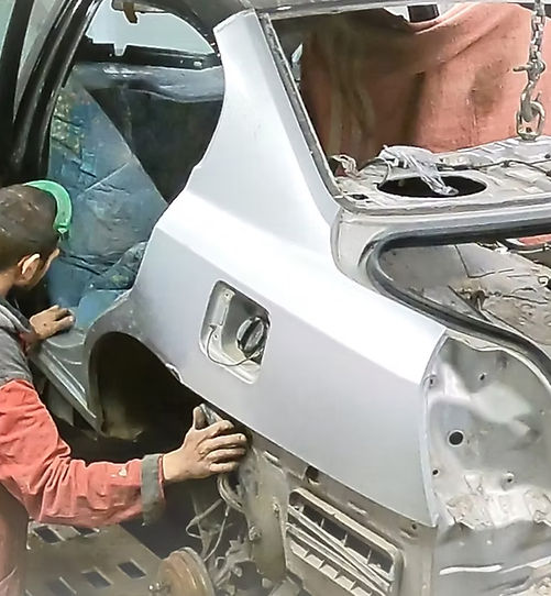 Auto mechanic repairing damaged car body panel