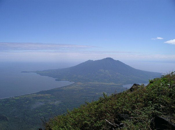 View of volcanoes on Ometepe Island, Nicaragua, with lush greenery and clear blue skies.