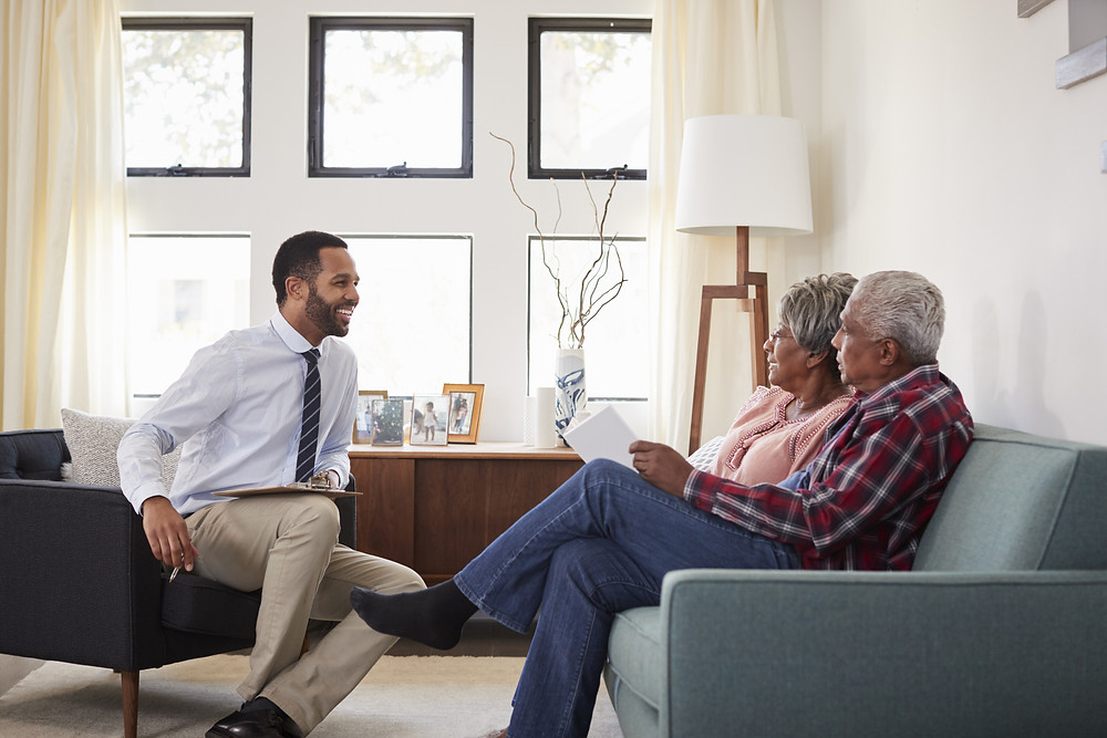 insurance agent meets with elderly couple to review their policies and make sure they're protected