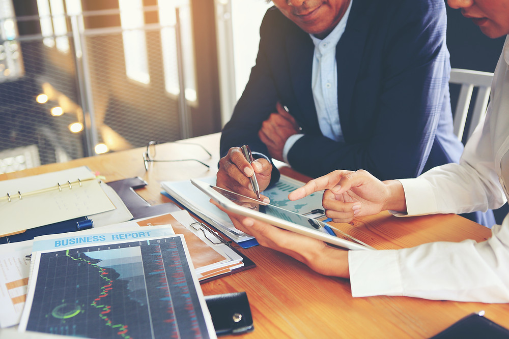 insurance agent and staff sit at desk to review ROI from customer insurance review appointments