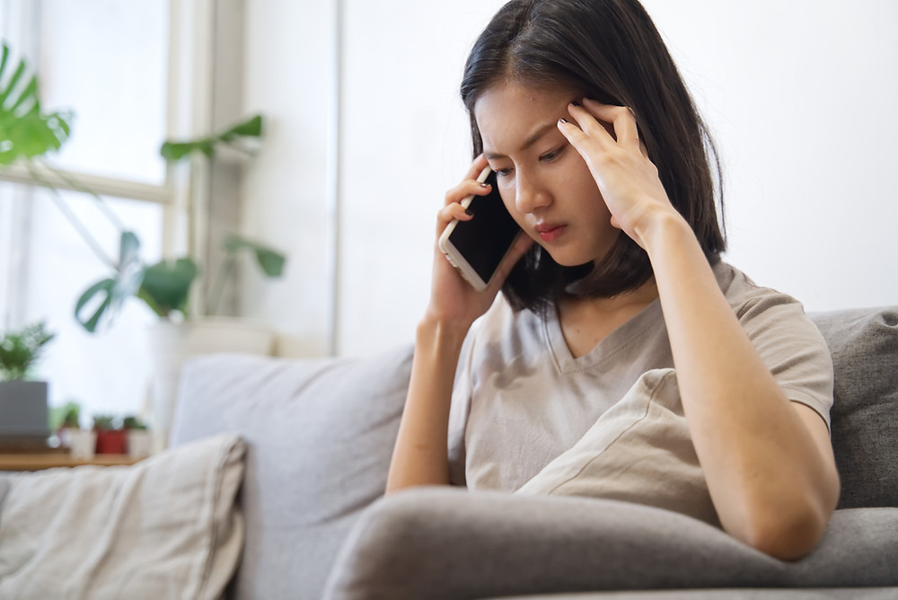 Woman looks frustrated on the phone with insurance agent.
