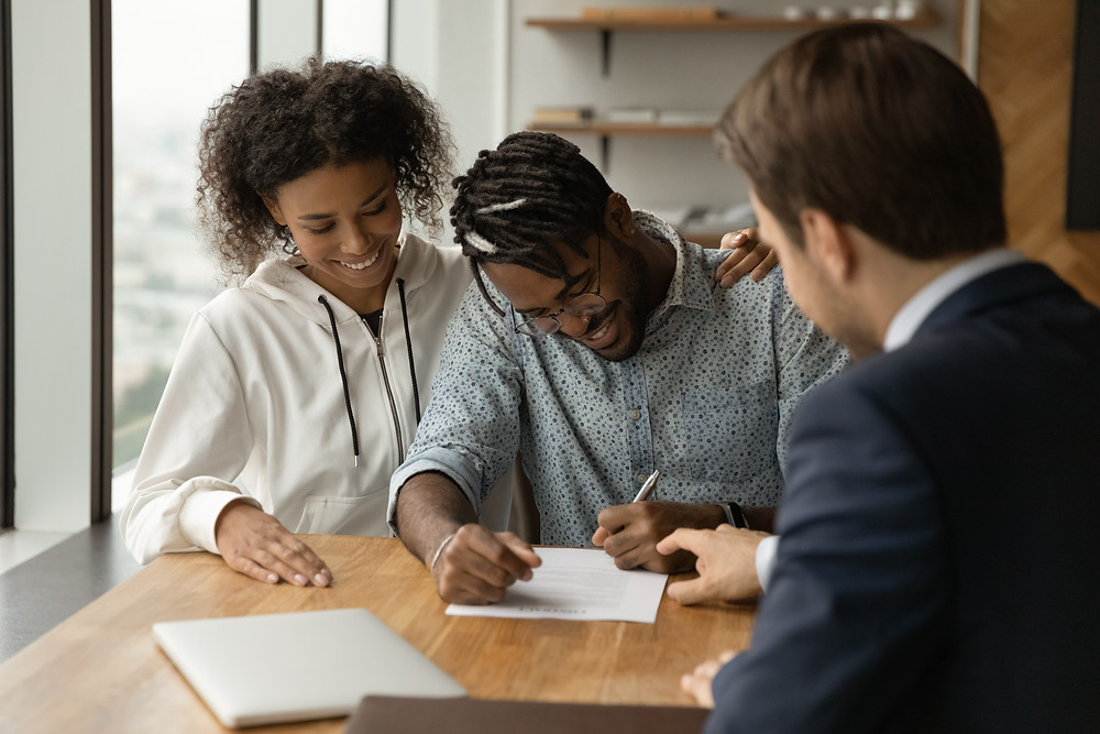 Young couple signs updated insurance policies.