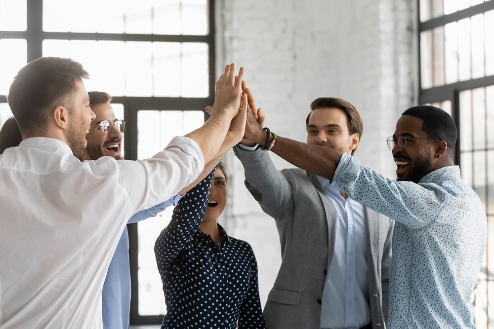 Insurance team high fives each other