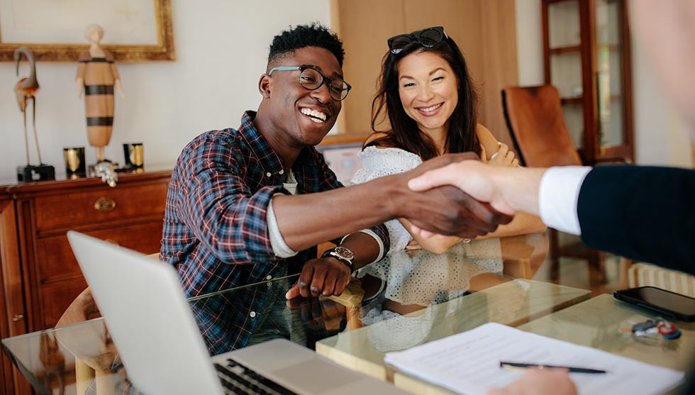 Millennial couple meets with their insurance agent.