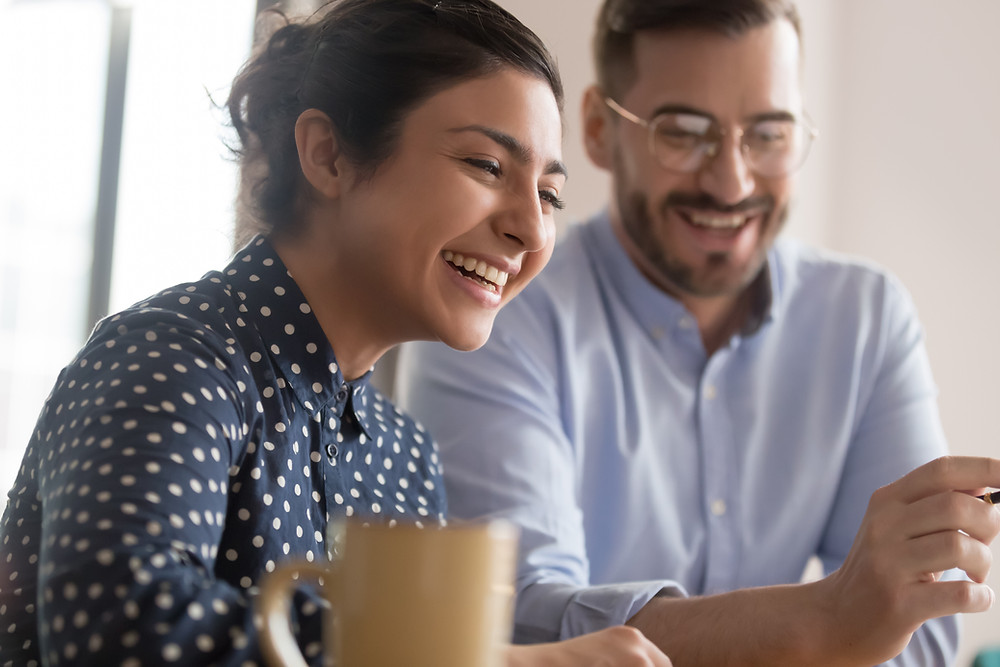 Happy customers sit in insurance office with their agent.
