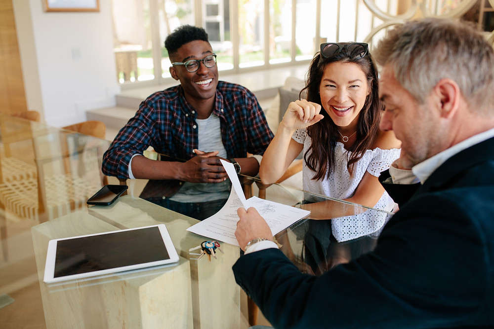 Insurance agent meets with young couple to review their policies.