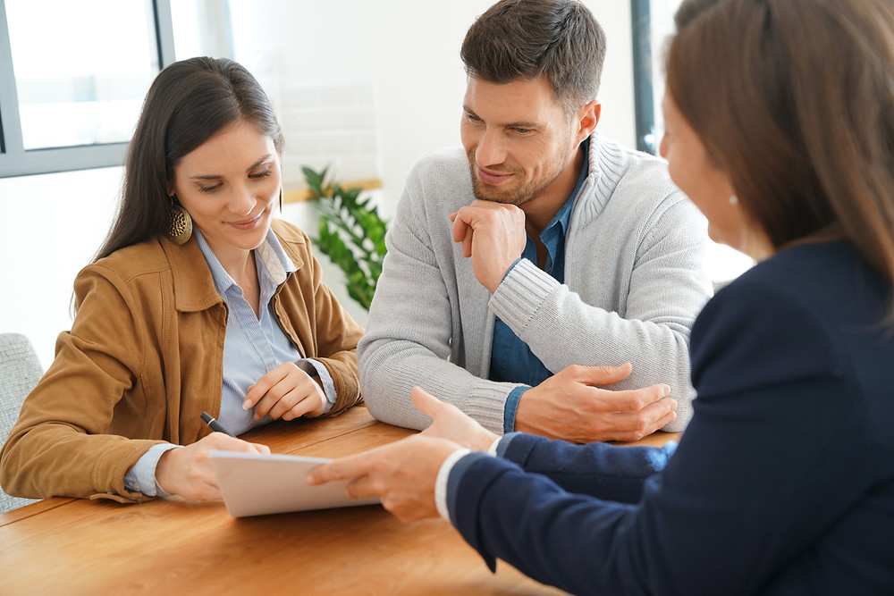 Insurance agent meets with young couple to review their coverage.