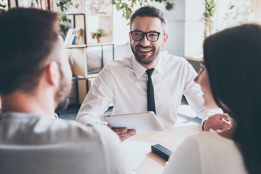 Insurance agent reviews policies with a couple.