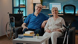 portrait-retired-couple-with-disability-sitting-couch-looking-camera-elder-man-woman-crutc