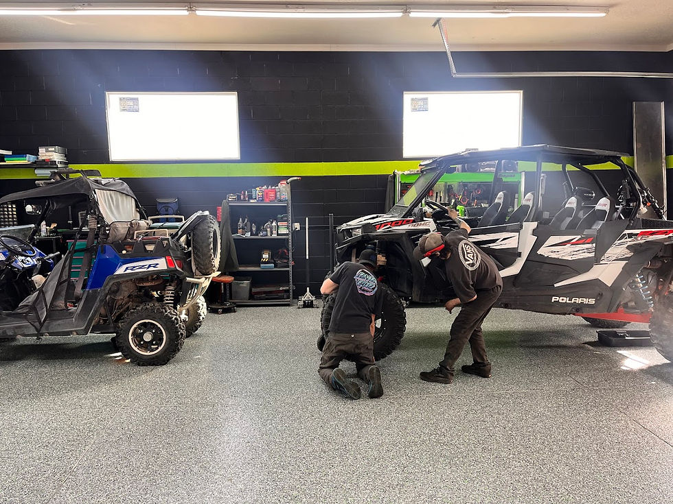 Impulse Powersports technicians servicing a powersports vehicle in the Lehi shop