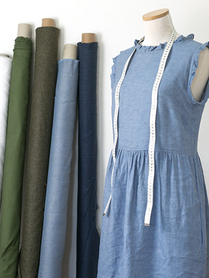 Aus dem Atelier, eine Schneiderpuppe und Stoffrollen.