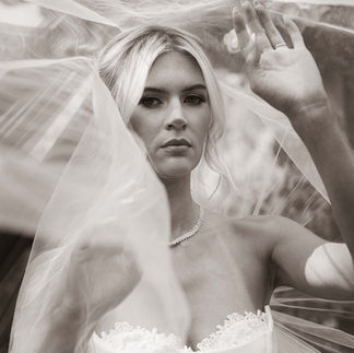 Blonde bride in wedding dress, veil, looking directly, black and white.