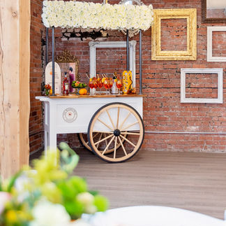 a cute bar cart against a brick wall