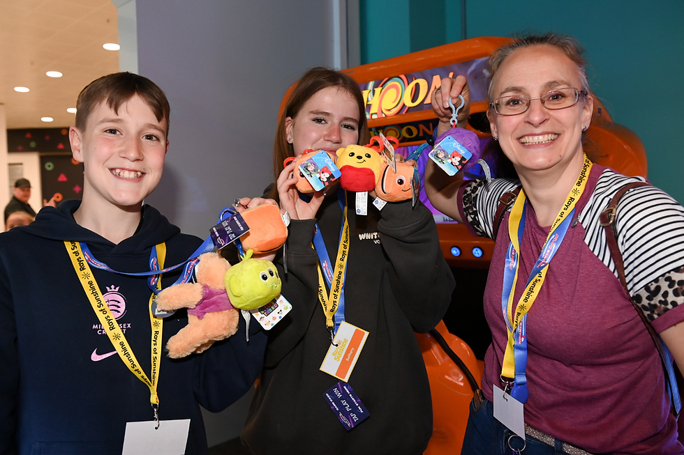 Group of three people showing the plush bagclip prizes they won at Funstation