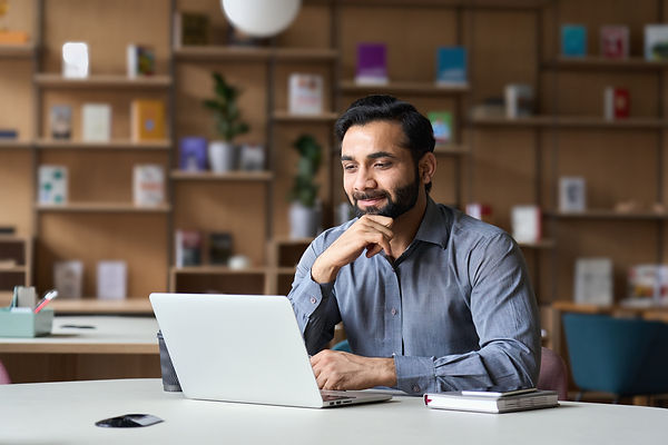 Smiling indian businessman working on la