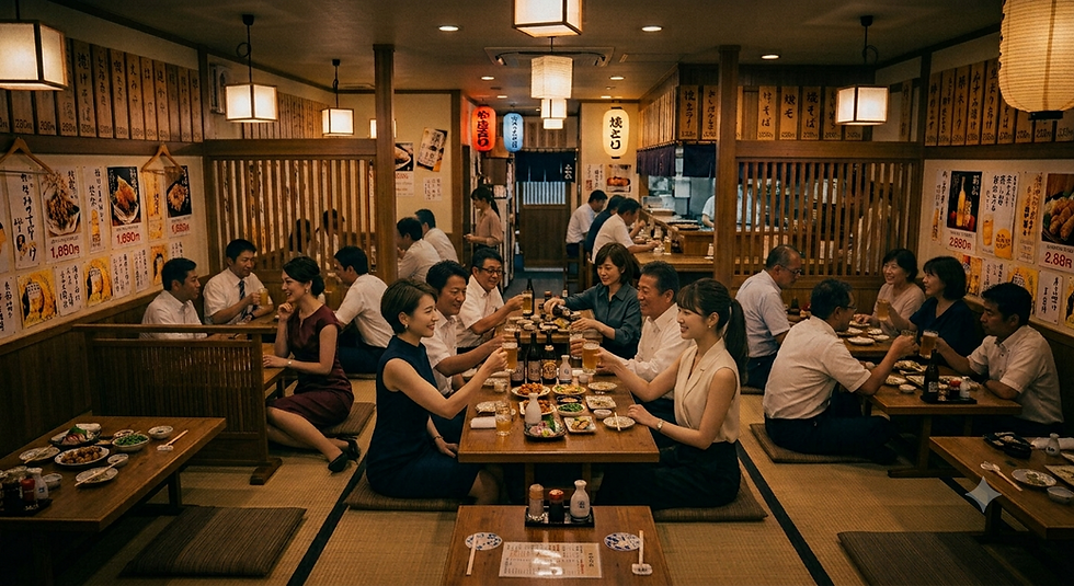 居酒屋の広々としたお座敷で、賑やかに暑気払いの宴会を楽しむ大人数のグループ。ビールや料理を囲み、笑顔で談笑しているアットホームな宴会の風景。
