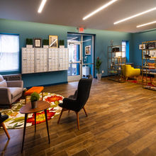 Decorated lobby with mail and package center, seating areas with accent tables, and bookshelves