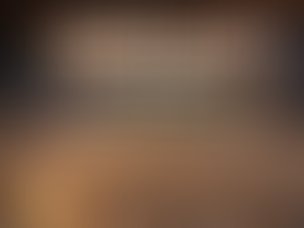 Pile of vermiculite insulation in an attic, flashlight on left. Person kneels in background. Text: "Vermiculite Insulation in Colorado." Asbestos testing in Denver Colorado