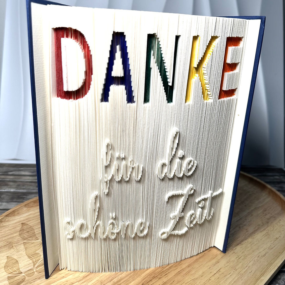 Handgefertigte Buchfaltkunst als Abschiedsgeschenk für Lehrer und Pädagogen mit farbigem Danke-Schriftzug zum Schulabschluss.