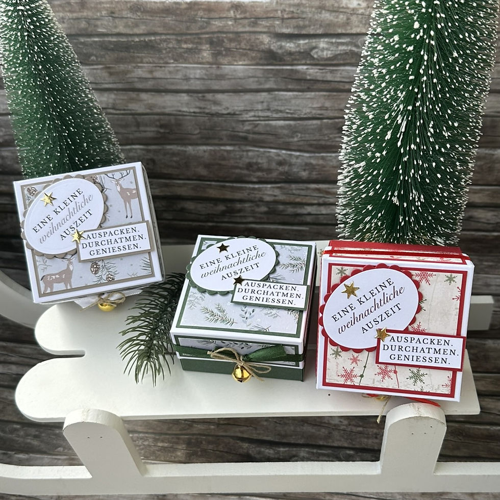 Miniaturbild: Drei Weihnachtsboxen in Taupe, Grün und Rot mit winterlichem Designpapier, dessen Muster je nach Verfügbarkeit variieren kann