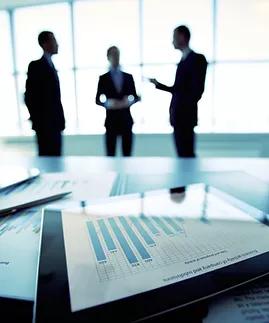 Tablet with graph in foreground, and pfigures in background