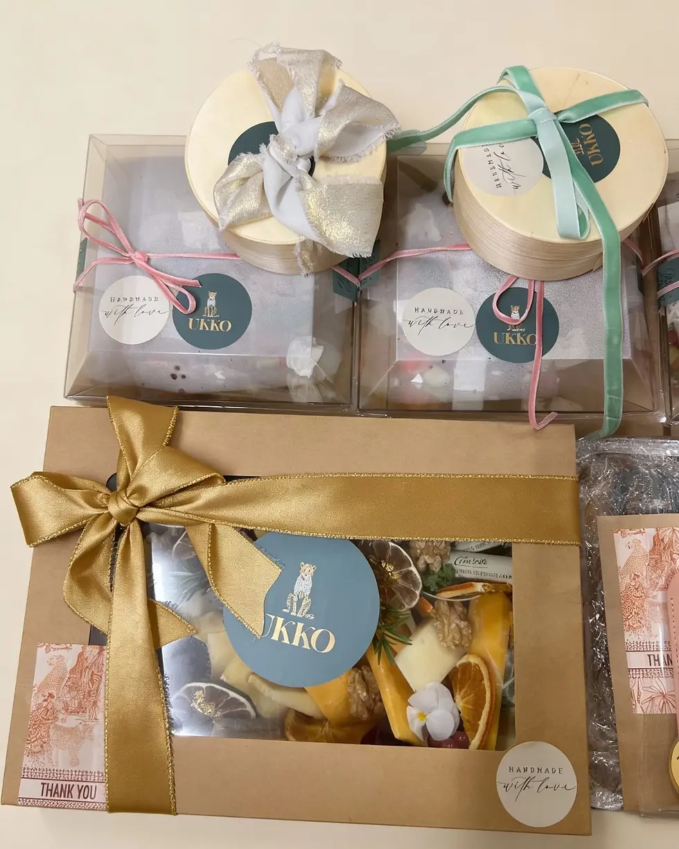Assorted handmade gift boxes with gold, pink, and mint ribbons, labeled UKKO and handmade with love, plus a Thank You tag.