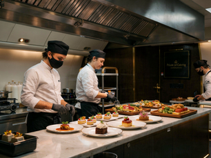 Kitchen staff plating and decorating dishes 