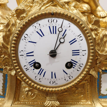 an antique French victorian ornate bronze gilt mantel clock with two cherubs fishing to the top of the case and painted porcelain panels. The movement is an eight day duration which strikes the hours on a bell with outside count wheel