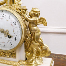 French Louis XVI style antique mantel clock with gilt bronze female and cherub figures with doves, on a white marble base with movement striking on a bell