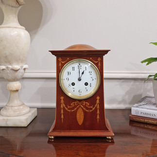 an antique French mahogany mantel clock with marquetry swag inlay to the front of the case in the Art Nouveau style