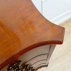 A Georgian mahogany serpentine fronted antique chest of drawers with four graduating drawers and wooden knobs, standing on bracket feet attributed to Gillows