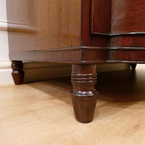 Regency mahogany bow fronted antique chest of drawers with brass handles standing on vase turned feet