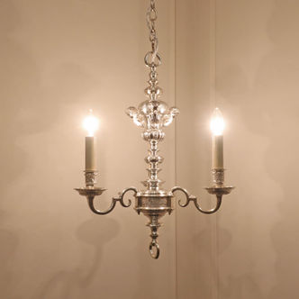 an antique silver plated three arm chandelier with shaped curved arms with leaf bobeche cups and term figures to the top with gadroon moulding