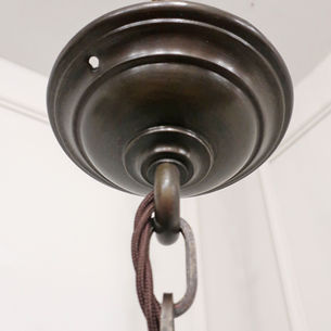 An Art Deco antique pendant light with hexagonal shaped frosted glass body and bronzed gallery, hanging on an adjustable chain with ceiling rose.
