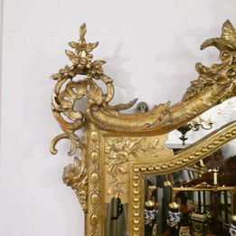 French late 19th century large antique gilt wall mirror in the Louis XVI style with cherub to the crest and bevelled mirror plate