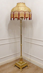A Victorian brass antique floor lamp with height adjustment and central fluted column standing on sqaure base