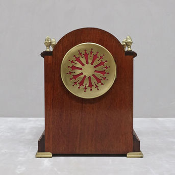 an antique French Edwardian mahogany table clock with eight day duration movement and white enamel dial with Roman numerals, finished with pineapple finials